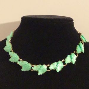 Gold tone choker with pretty green leaves. Perfect spring piece.